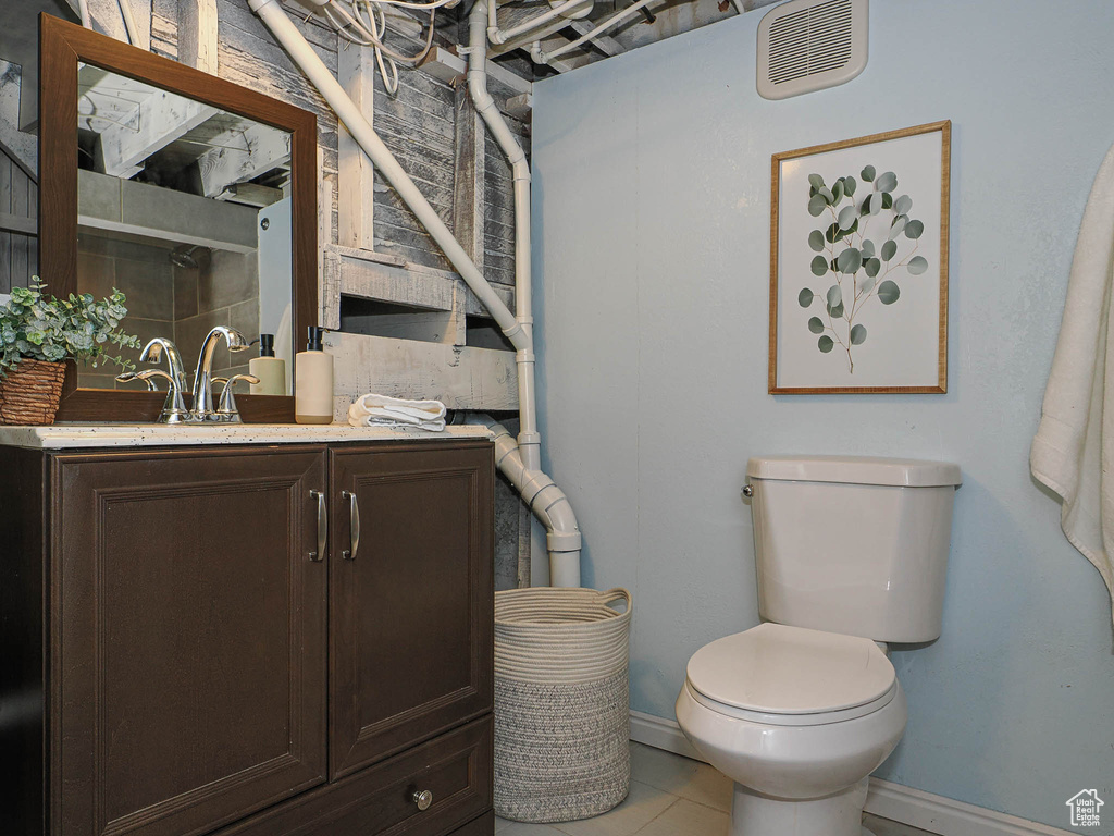 Bathroom with toilet, baseboards, visible vents, and vanity