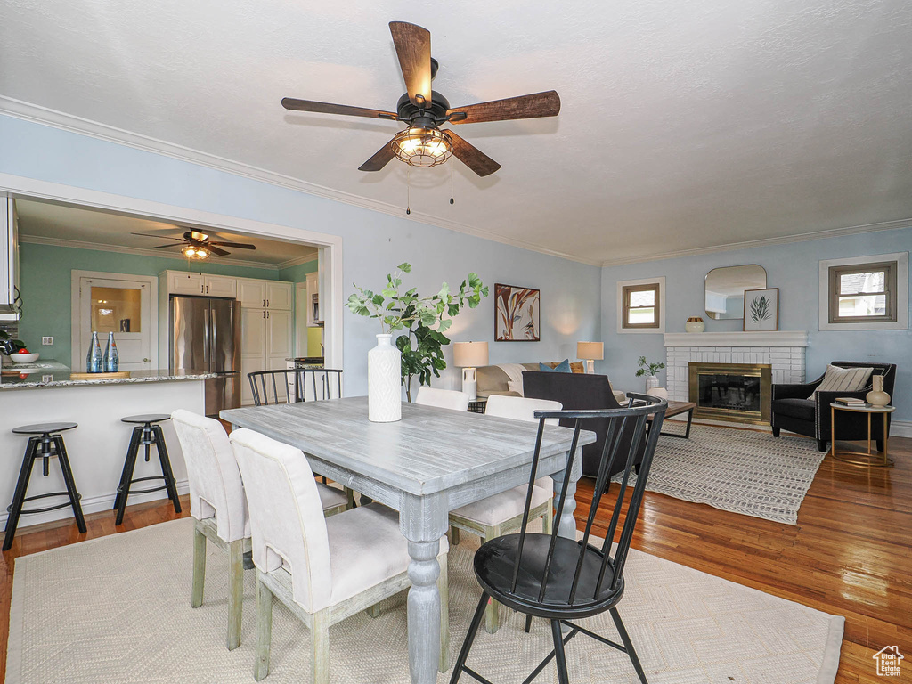 Dining room with crown molding, a ceiling fan, and wood finished floors