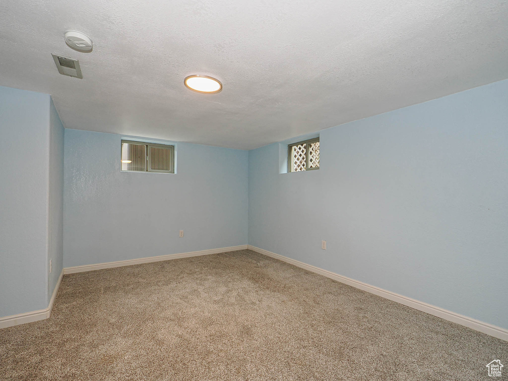 Basement featuring baseboards and carpet flooring