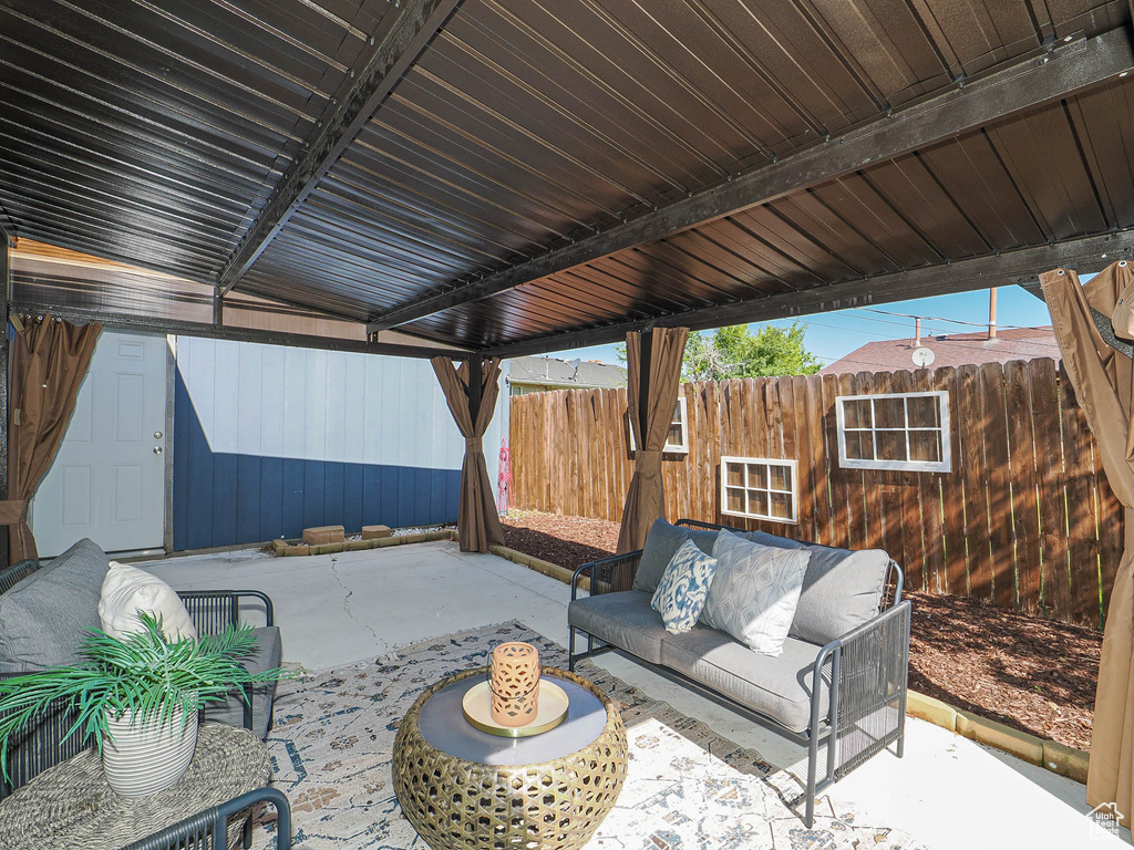 View of patio with an outdoor living space and fence