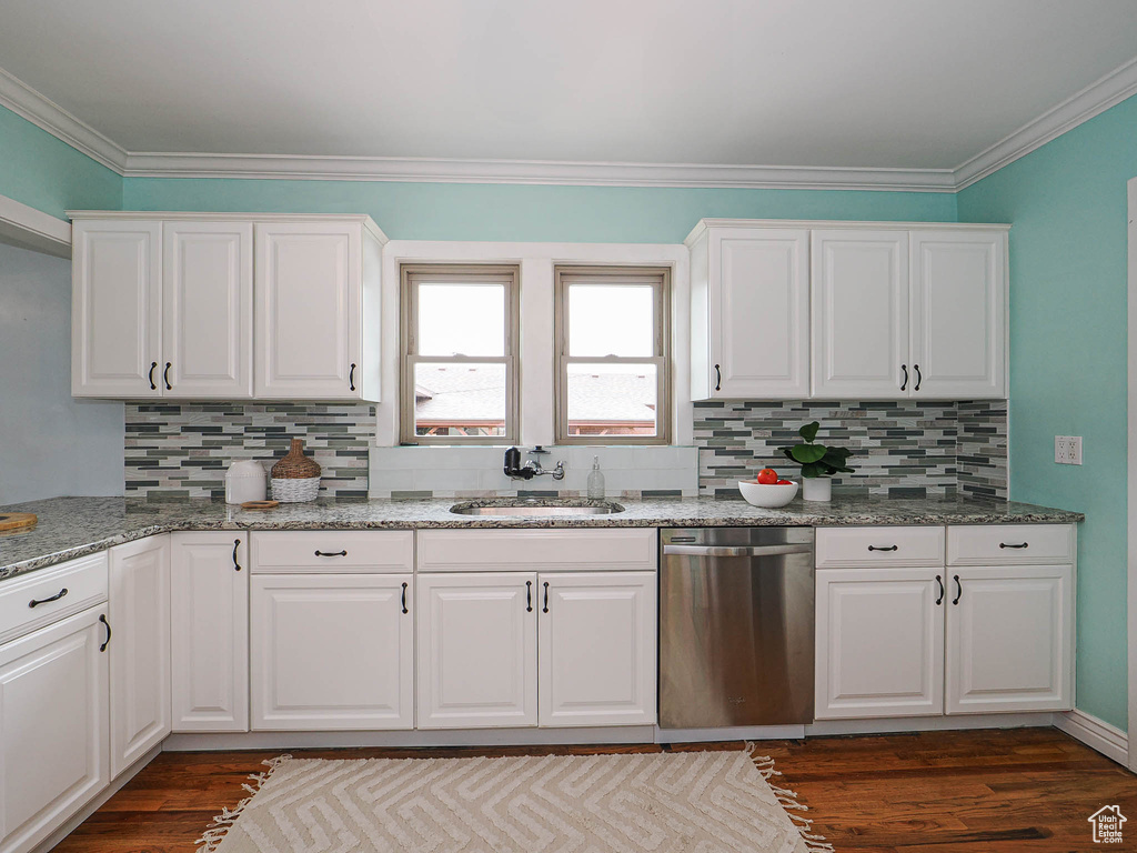 Kitchen featuring a sink, dark wood finished floors, decorative backsplash, stainless steel dishwasher, and ornamental molding