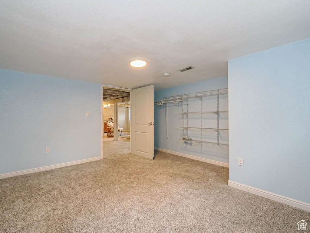 Spare room with baseboards, light carpet, and visible vents