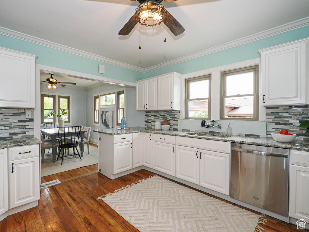 Kitchen with stainless steel dishwasher, a ceiling fan, light wood-style floors, tasteful backsplash, and a sink