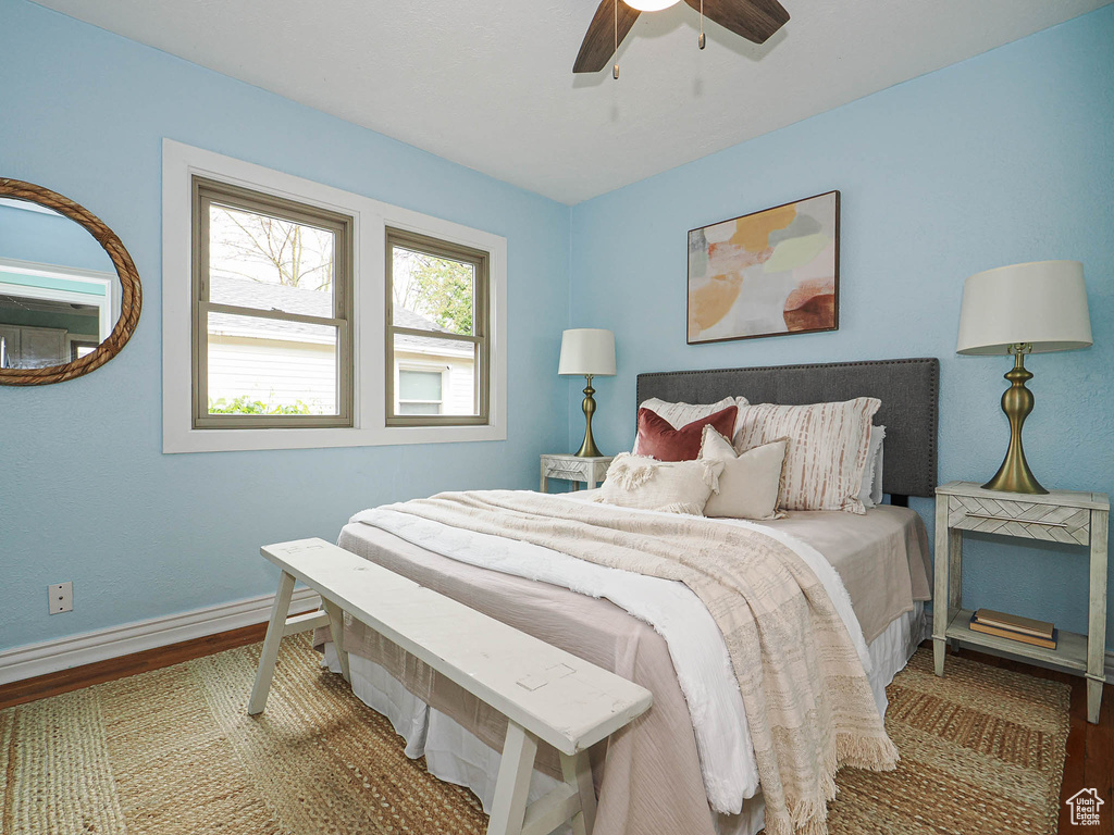 Bedroom with a ceiling fan, baseboards, and wood finished floors