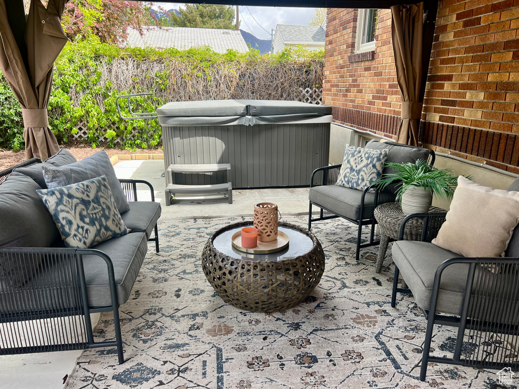 View of patio with a hot tub and an outdoor hangout area