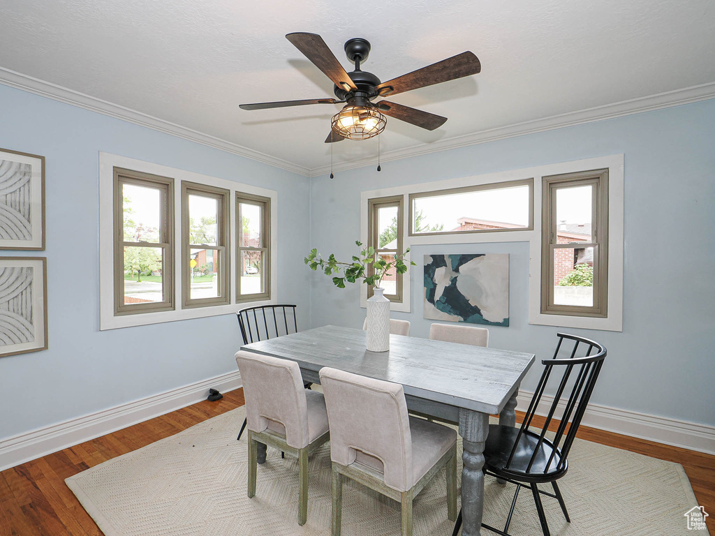 Dining space with baseboards, ornamental molding, ceiling fan, and wood finished floors