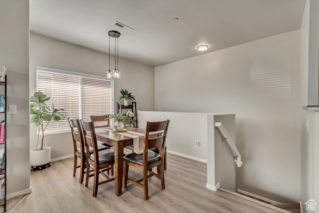 Dining space featuring visible vents, light wood-style flooring, and baseboards