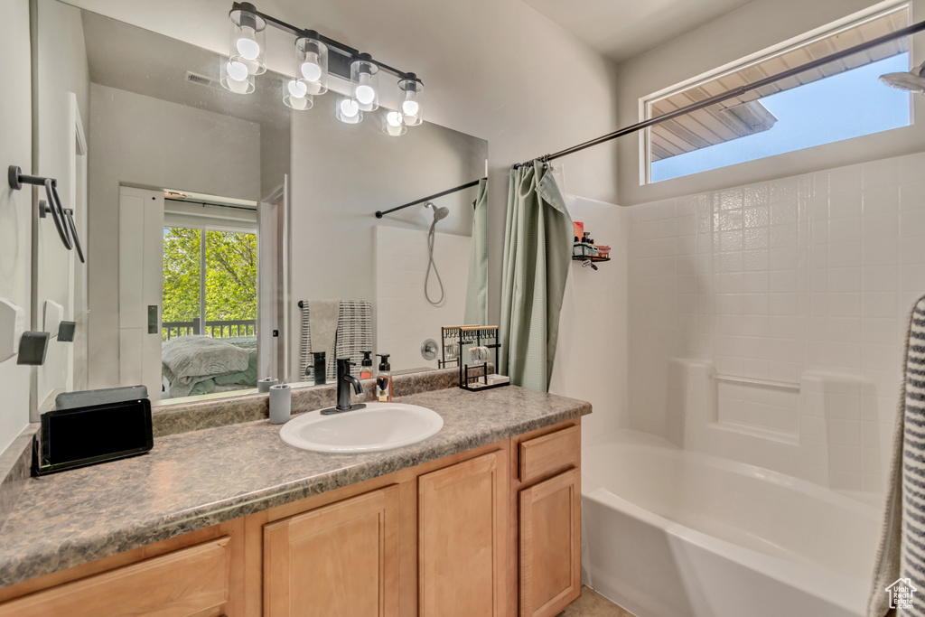 Bathroom with ensuite bathroom, shower / bath combo, and vanity