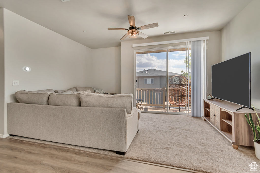 Living area with ceiling fan, visible vents, and wood finished floors