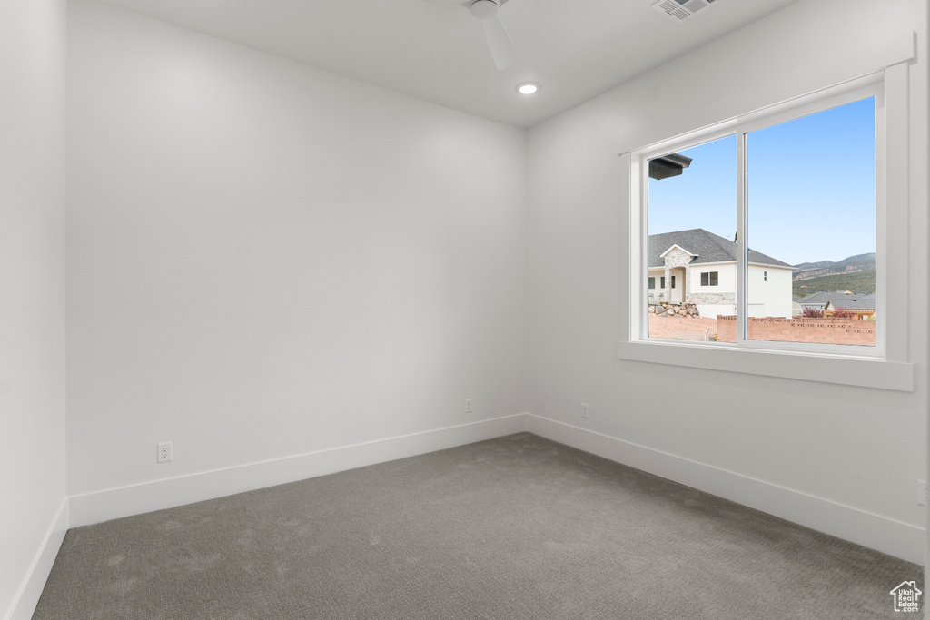 Carpeted spare room featuring baseboards, a ceiling fan, and recessed lighting