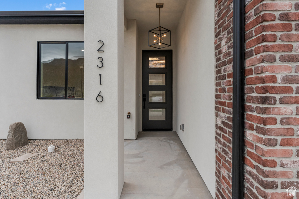 View of exterior entry featuring brick siding and stucco siding