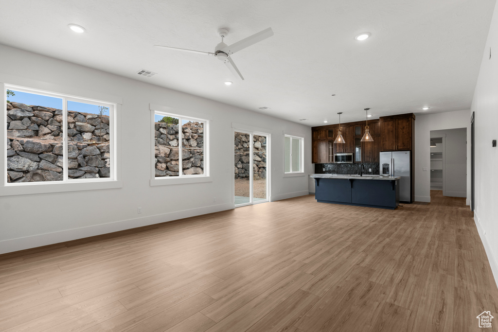 Unfurnished living room featuring baseboards, a ceiling fan, recessed lighting, and visible vents