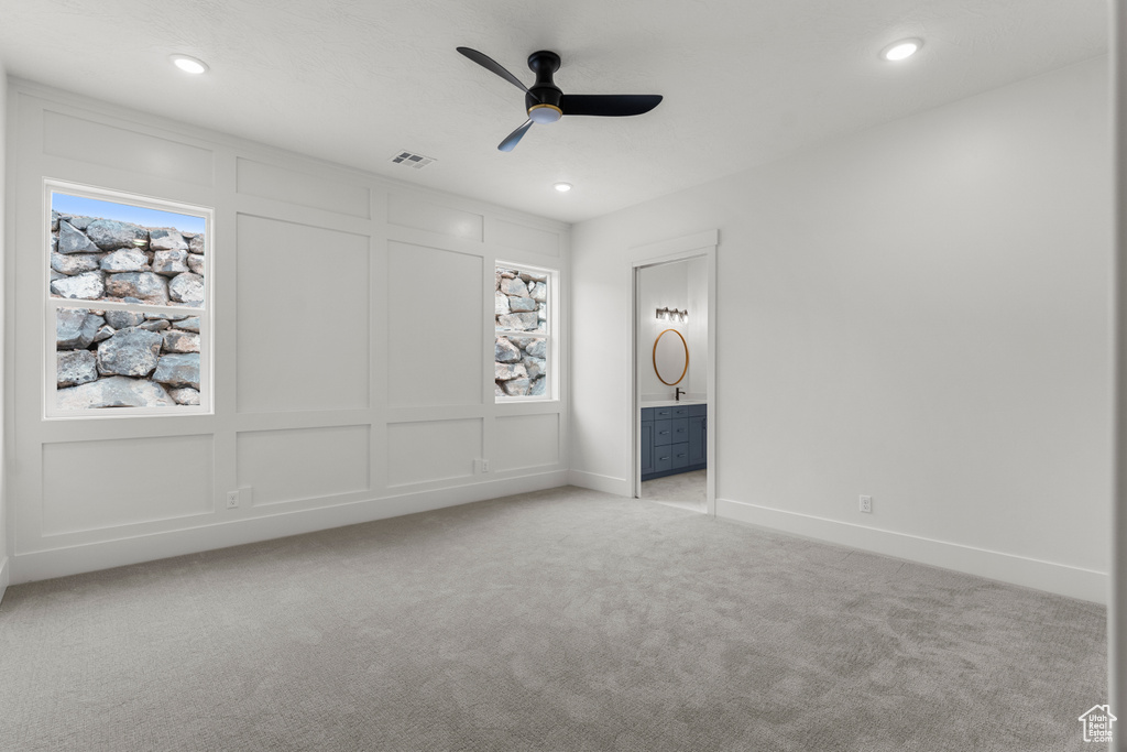 Interior space featuring connected bathroom, recessed lighting, baseboards, and light colored carpet