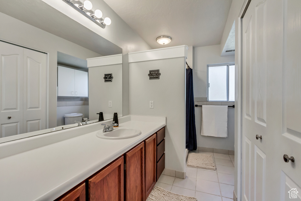 Bathroom with vanity, tile patterned floors, and toilet
