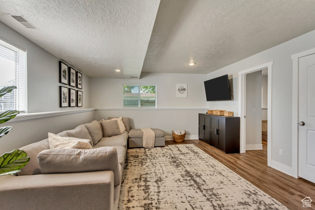 Living area with visible vents, recessed lighting, a textured ceiling, and wood finished floors