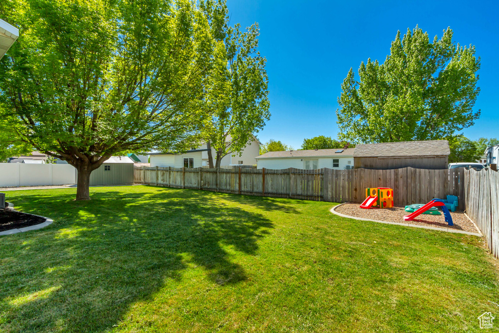 View of yard with a fenced backyard and a playground