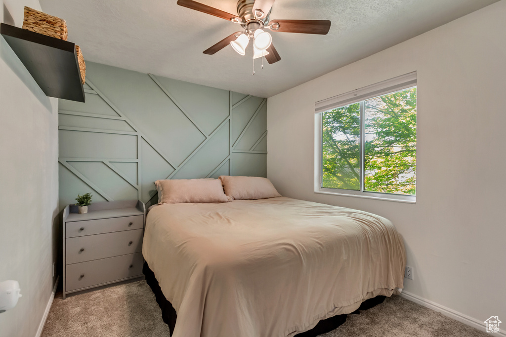 Carpeted bedroom featuring baseboards and ceiling fan