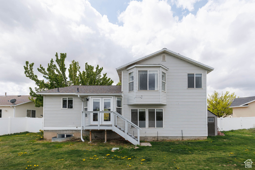 Back of property featuring a lawn and fence