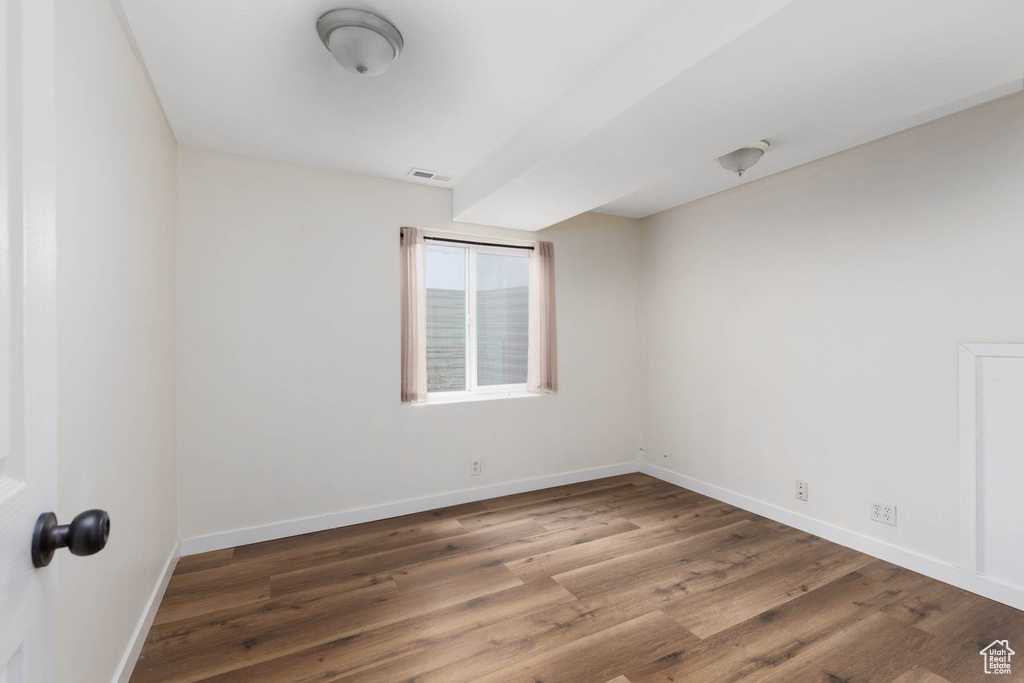 Spare room with baseboards, wood finished floors, and visible vents
