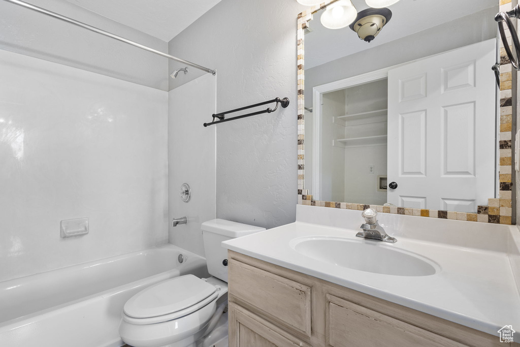 Bathroom featuring shower / bath combination, vanity, and toilet