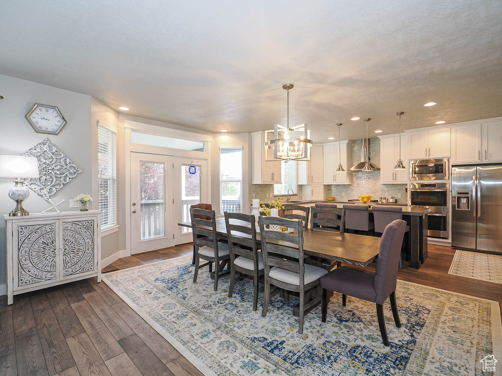 Dining area with recessed lighting, baseboards, dark wood-style floors, and a notable chandelier