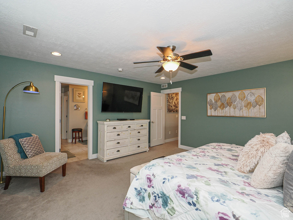 Bedroom featuring baseboards, ceiling fan, visible vents, and light carpet