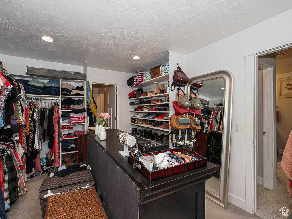 Spacious closet featuring light colored carpet