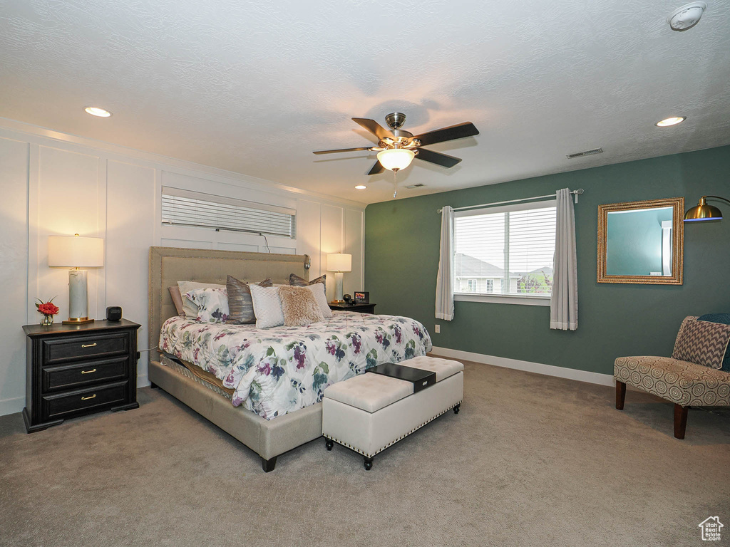 Bedroom with baseboards, light colored carpet, recessed lighting, and visible vents