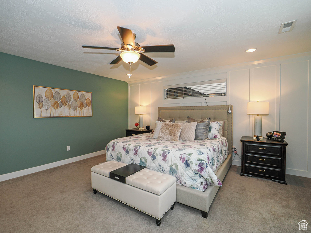 Carpeted bedroom with visible vents, baseboards, recessed lighting, a textured ceiling, and a ceiling fan