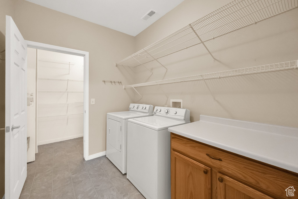 Washroom with independent washer and dryer, baseboards, and visible vents