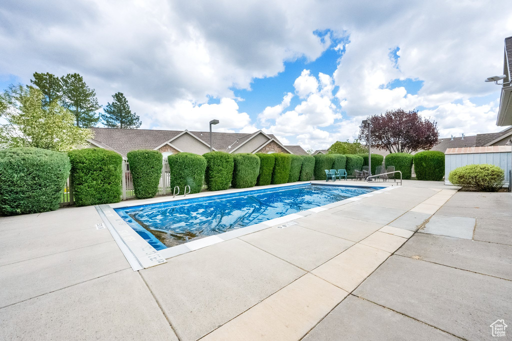 View of swimming pool with a fenced in pool, a patio area, and fence
