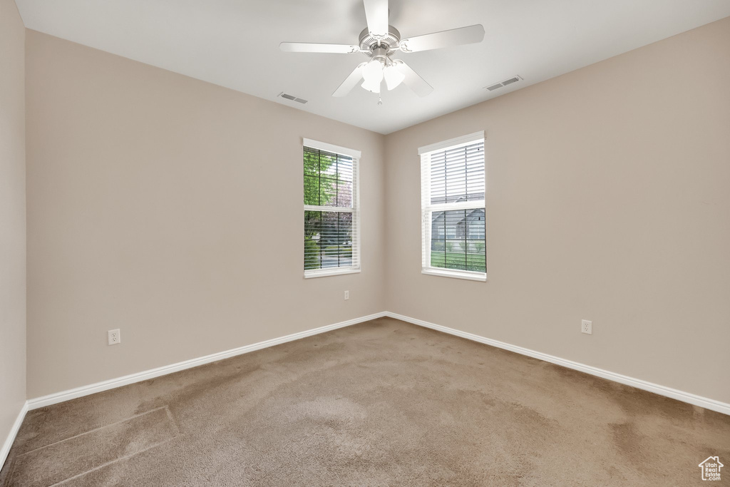 Unfurnished room with visible vents, carpet, and baseboards