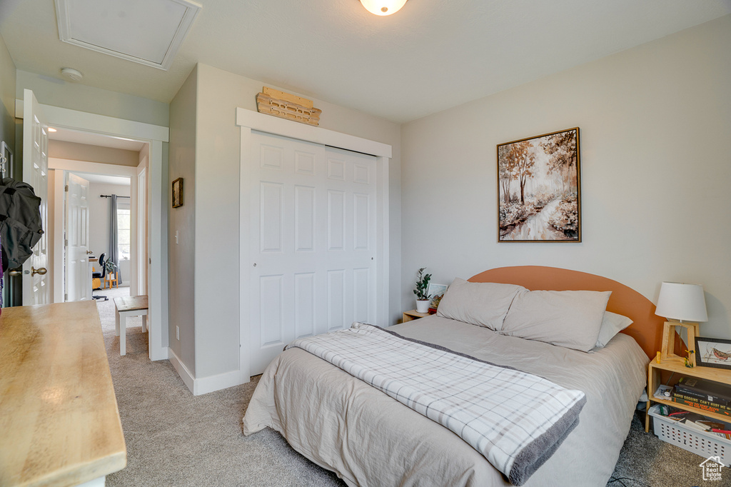 Bedroom with baseboards, light colored carpet, and a closet