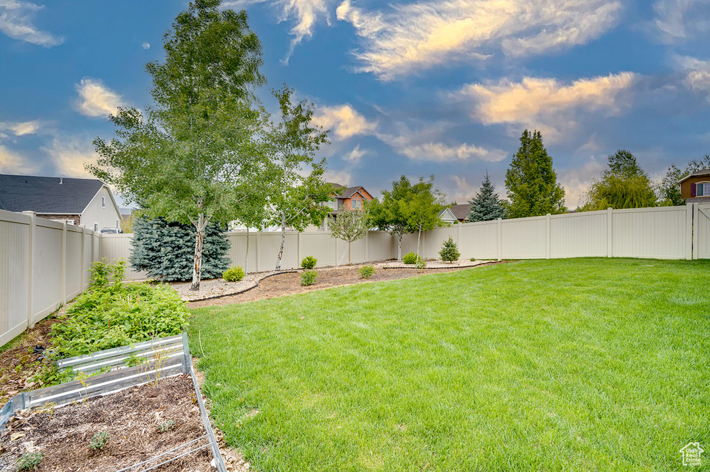 View of yard featuring a fenced backyard and a garden