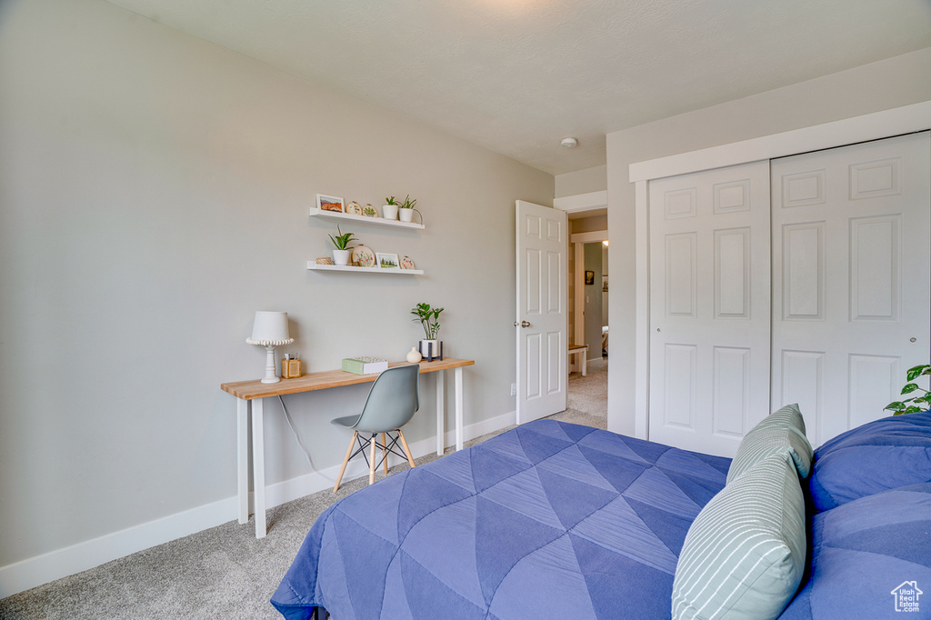 Carpeted bedroom featuring baseboards and a closet