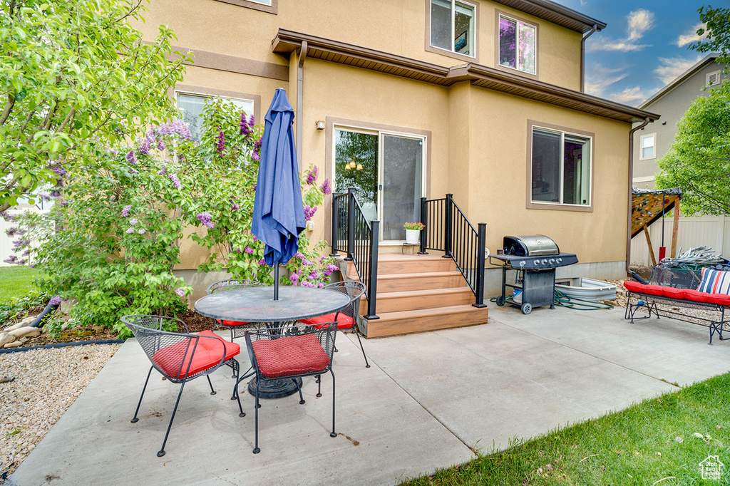 Back of house featuring a patio, outdoor dining area, and stucco siding