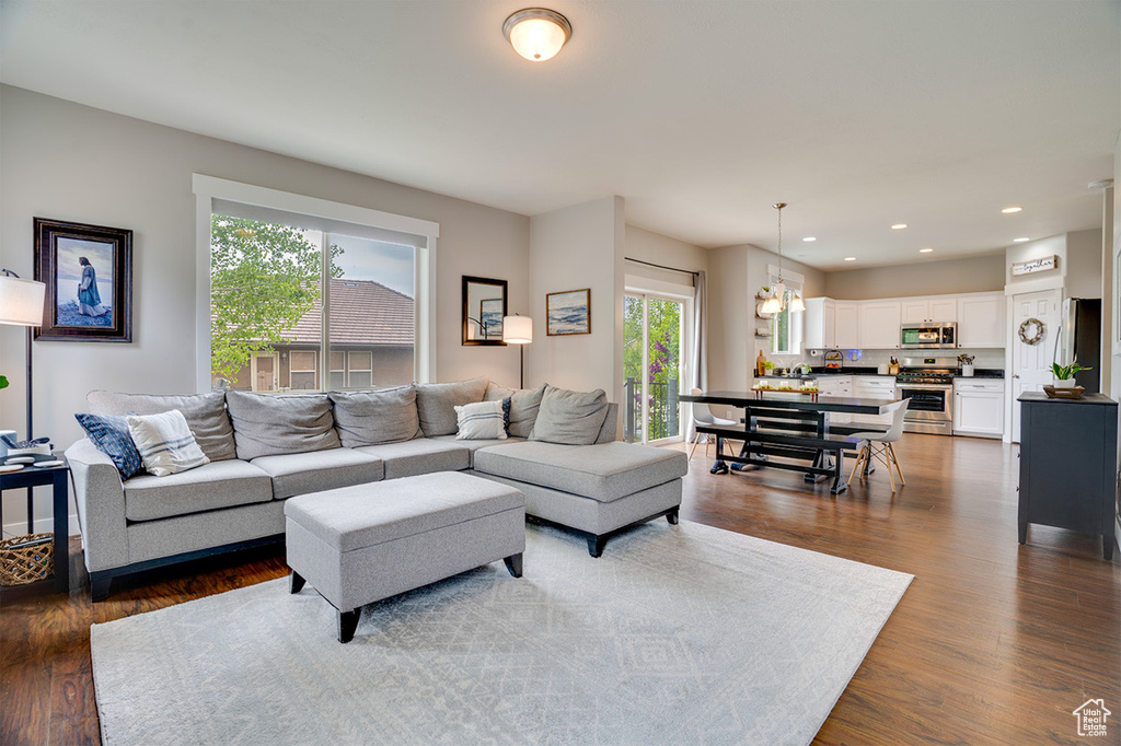 Living area with recessed lighting, dark wood-style flooring, and a chandelier