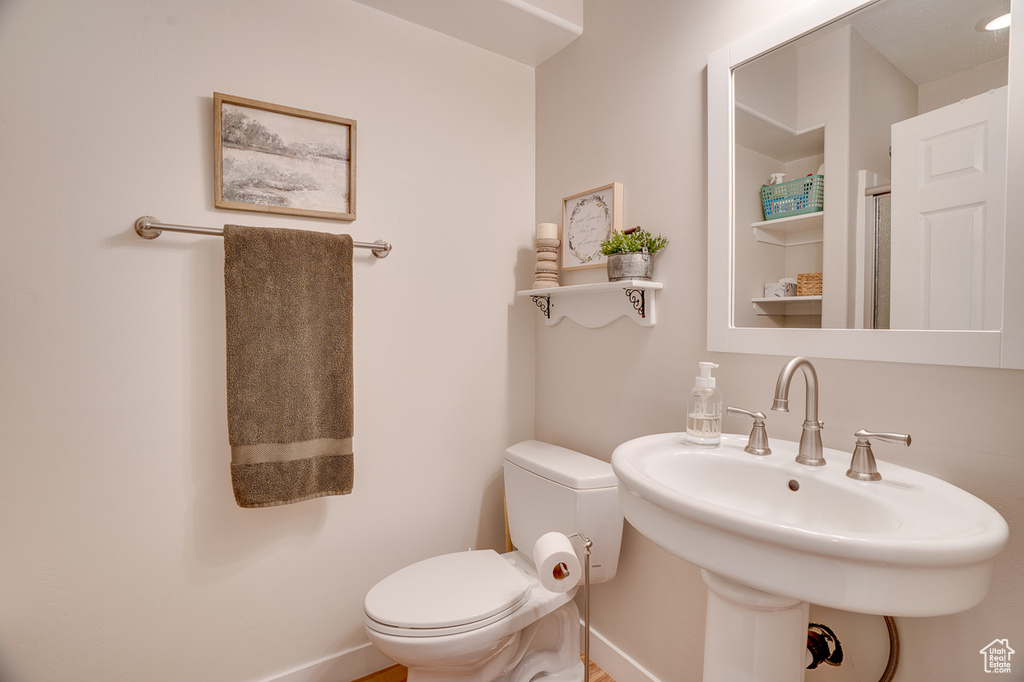 Bathroom featuring a sink, baseboards, and toilet