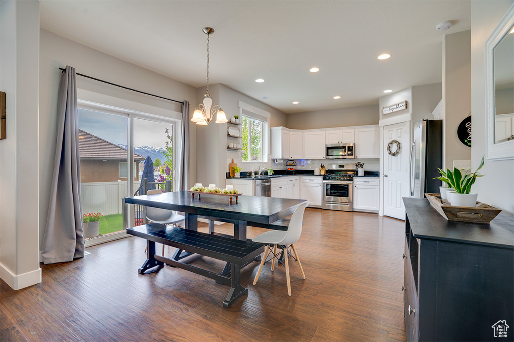Dining space with recessed lighting, baseboards, a notable chandelier, and dark wood-type flooring