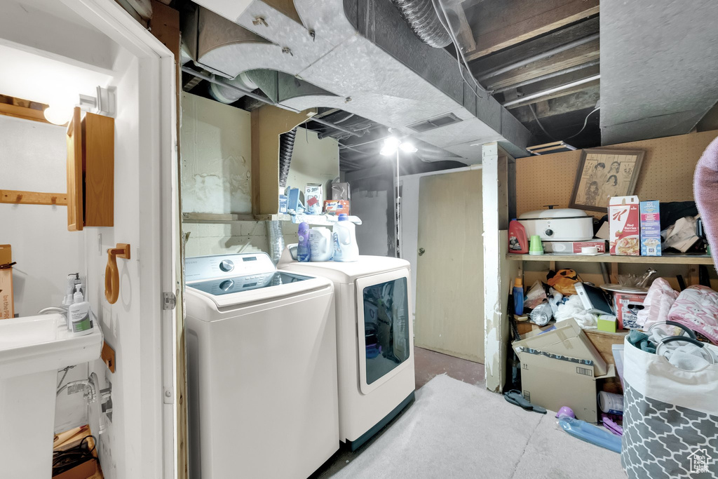 Clothes washing area with laundry area, a sink, washing machine and dryer, and visible vents
