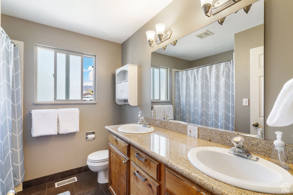 Bathroom featuring visible vents, a sink, and toilet