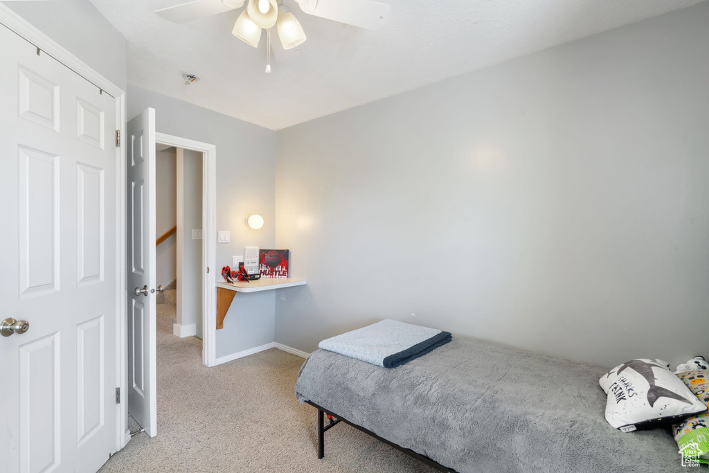 Bedroom featuring baseboards, carpet flooring, and a ceiling fan