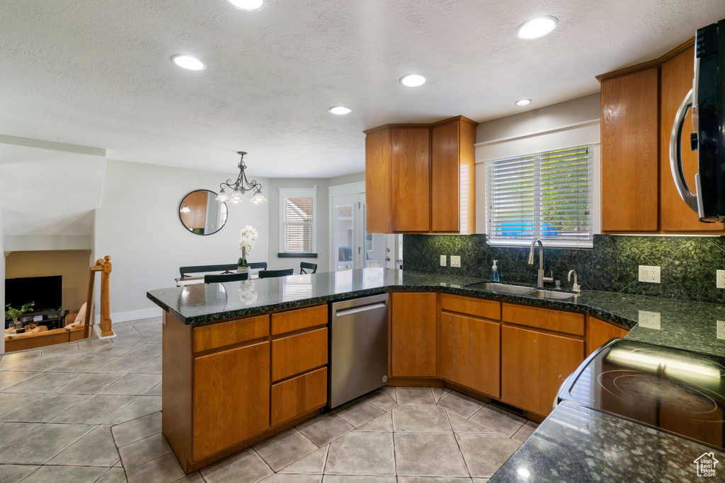 Kitchen featuring a sink, a healthy amount of sunlight, a peninsula, and dishwasher