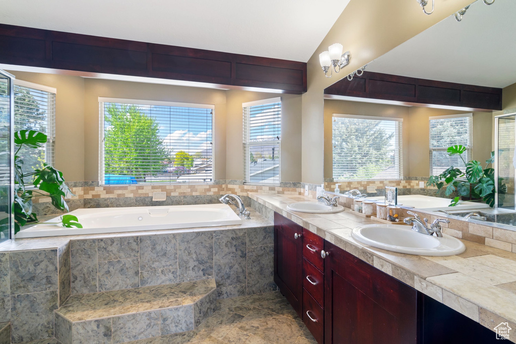 Bathroom with a sink, double vanity, and a bath