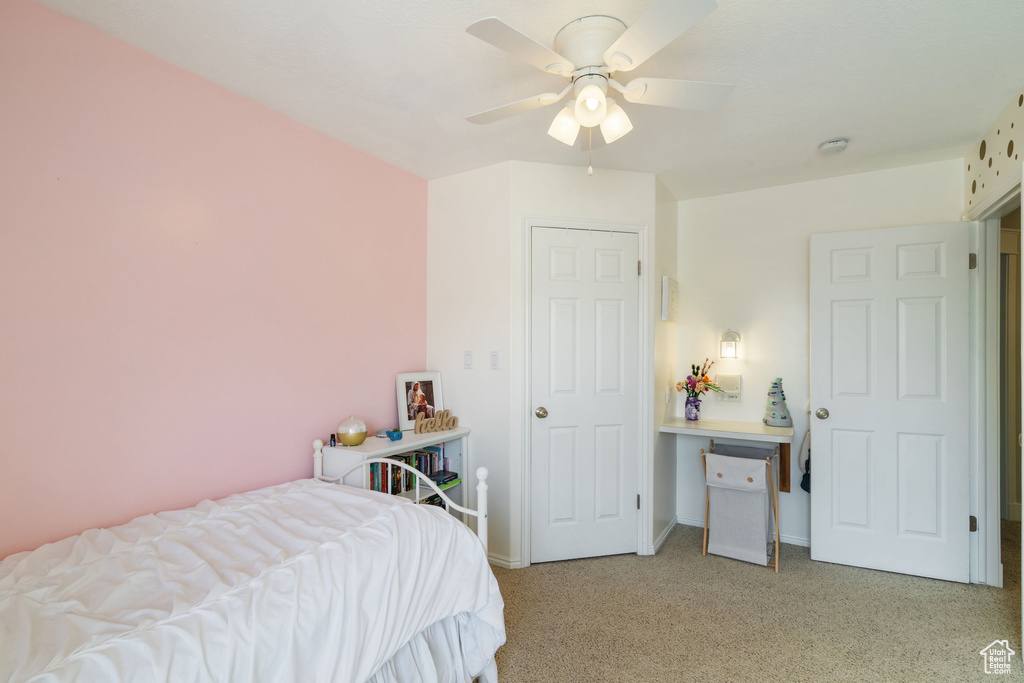 Bedroom with baseboards, ceiling fan, and light colored carpet
