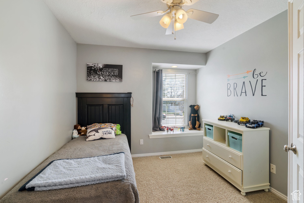 Bedroom with baseboards, light colored carpet, ceiling fan, and visible vents