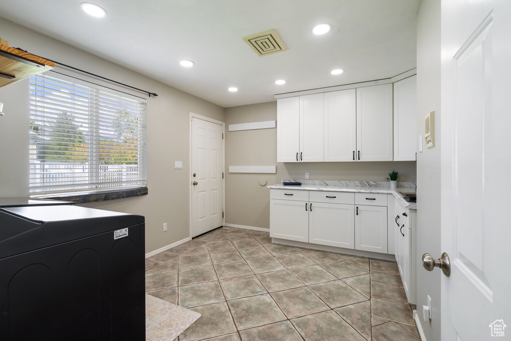 Washroom featuring cabinet space, light tile patterned flooring, washer / clothes dryer, recessed lighting, and visible vents