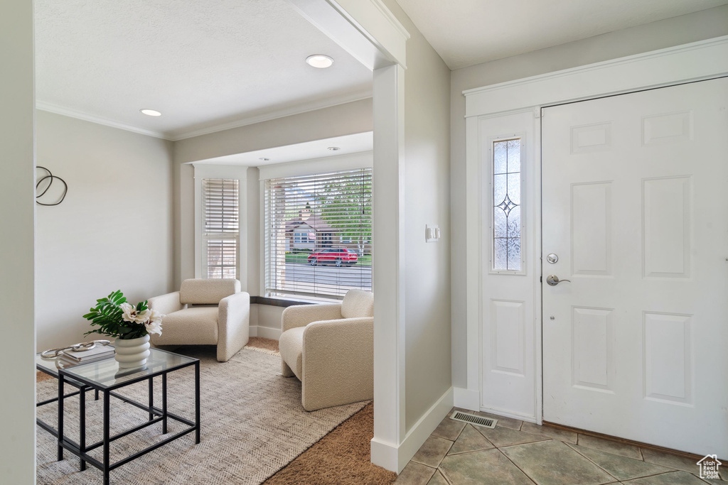 Entryway featuring crown molding, baseboards, plenty of natural light, and visible vents