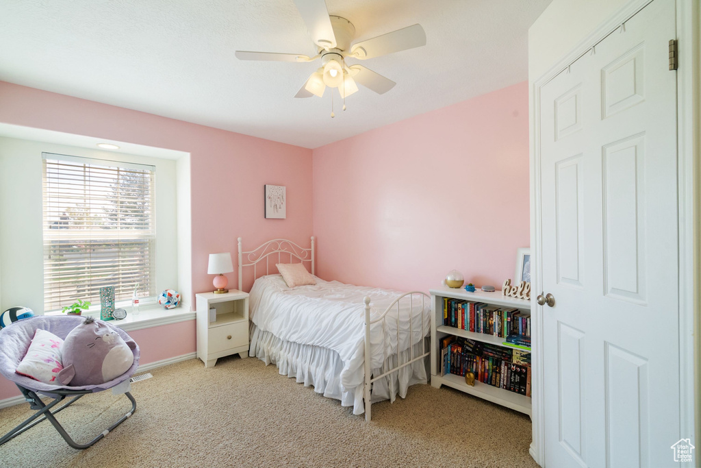 Bedroom featuring baseboards, a ceiling fan, and light colored carpet
