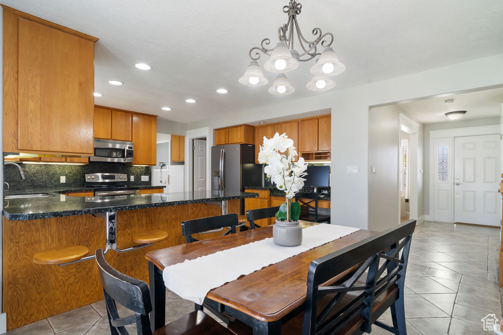 Dining room featuring recessed lighting, light tile patterned flooring, and a notable chandelier